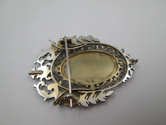 Broche mujer. Metal blanco y dorado. Cerco calado floreado. Cántaro y cesta. 1950