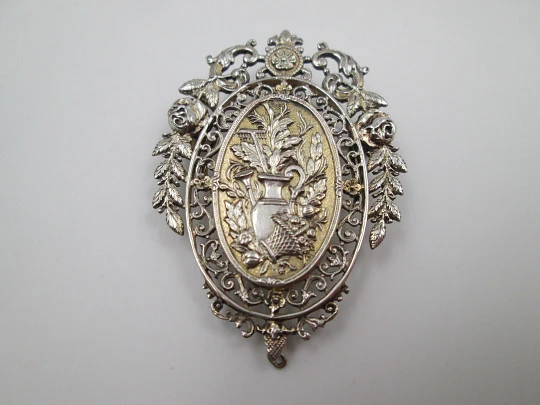 Broche mujer. Metal blanco y dorado. Cerco calado floreado. Cántaro y cesta. 1950