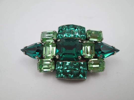 Broche para mujer. Metal plateado y gemas facetadas verdes. Estados Unidos. 1960