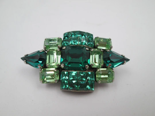 Broche para mujer. Metal plateado y gemas facetadas verdes. Estados Unidos. 1960