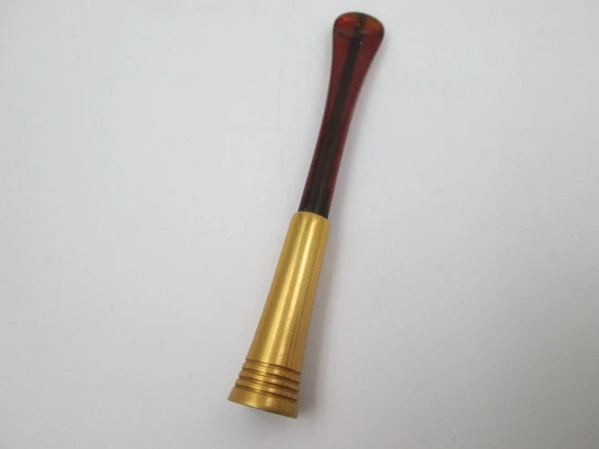 Cigarette mouthpiece with spring. Golden metal and amber celluloid. Europe. 1940's