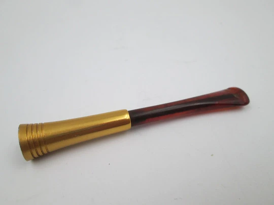 Cigarette mouthpiece with spring. Golden metal and amber celluloid. Europe. 1940's