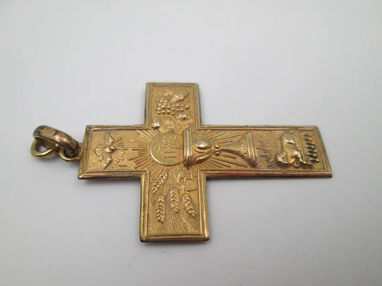 Cruz colgante con símbolos cristianos. Metal chapado oro. Asa y argolla. España. 1950