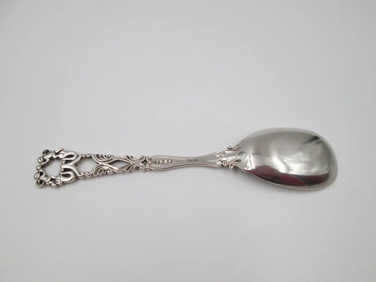 Cuchara larga con mango calado Bruckmann & Söhne. Remate de querubines. Plata. 1910