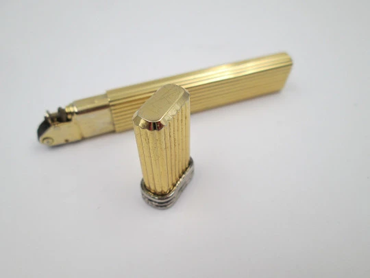 Mica pocket butane lighter. Gold plated and silver metal. Linear pattern. South America