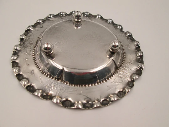 Ornate sterling silver salver. Chiseled floral motifs. Three legs and irregular edge. 1970's