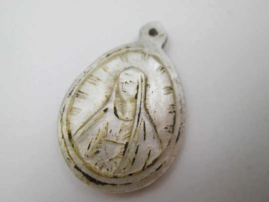 Oval nacre medal. Virgin with mantle and radiant crown. Hole on top. 1910's. Spain