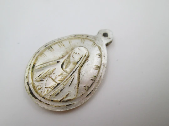 Oval nacre medal. Virgin with mantle and radiant crown. Hole on top. 1910's. Spain