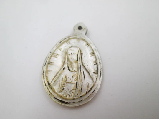 Oval nacre medal. Virgin with mantle and radiant crown. Hole on top. 1910's. Spain