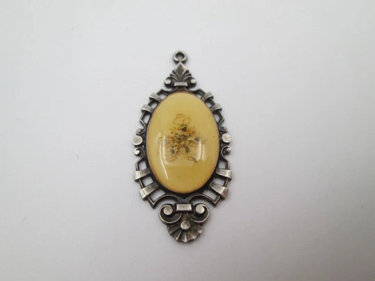 Oval pendant with openwork edge. Painted ivory and sterling silver. Flowers motif. 1910's