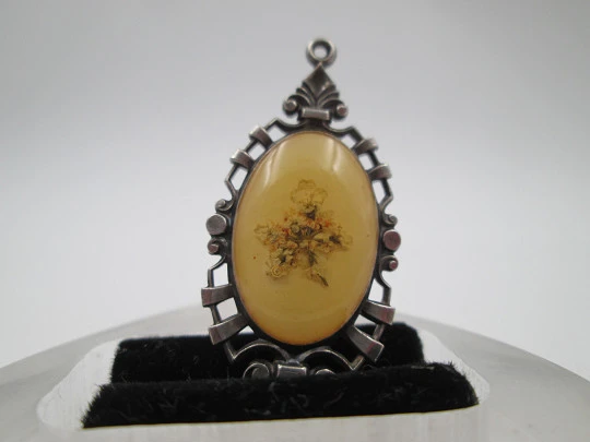 Oval pendant with openwork edge. Painted ivory and sterling silver. Flowers motif. 1910's