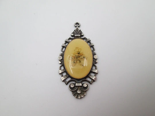 Oval pendant with openwork edge. Painted ivory and sterling silver. Flowers motif. 1910's