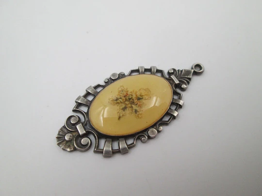 Oval pendant with openwork edge. Painted ivory and sterling silver. Flowers motif. 1910's