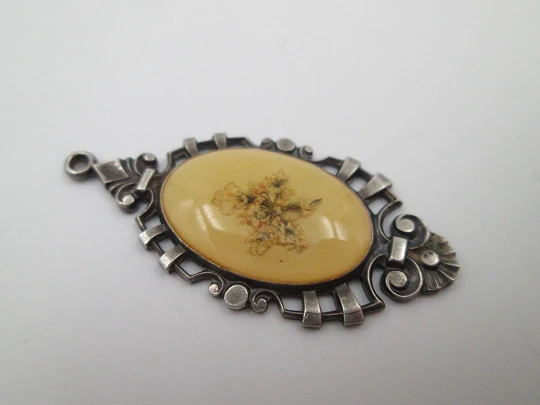 Oval pendant with openwork edge. Painted ivory and sterling silver. Flowers motif. 1910's