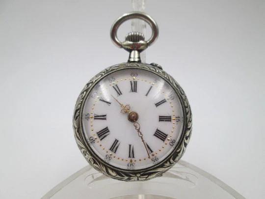 Reloj bolsillo metal plateado. Esfera porcelana. Remontoir con pulsador. Querubines. 1890