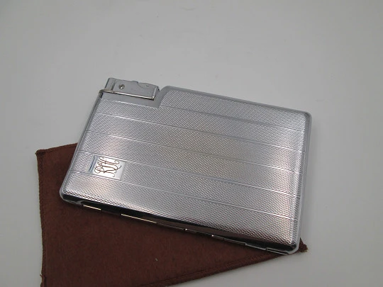 Seigneur cigarette case with petrol lighter. Silver plated metal. Lines and waves motifs