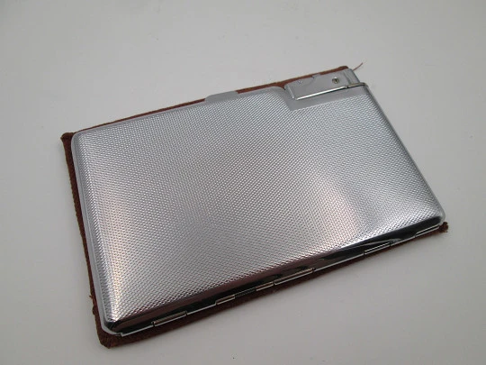 Seigneur cigarette case with petrol lighter. Silver plated metal. Lines and waves motifs