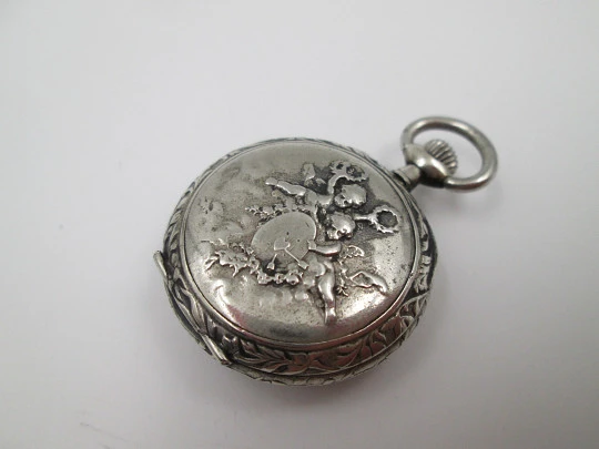 Silver plated open-faced pocket watch. Stem-wind. Porcelain dial. Cherubs motifs. 1890