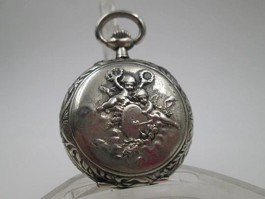 Silver plated open-faced pocket watch. Stem-wind. Porcelain dial. Cherubs motifs. 1890