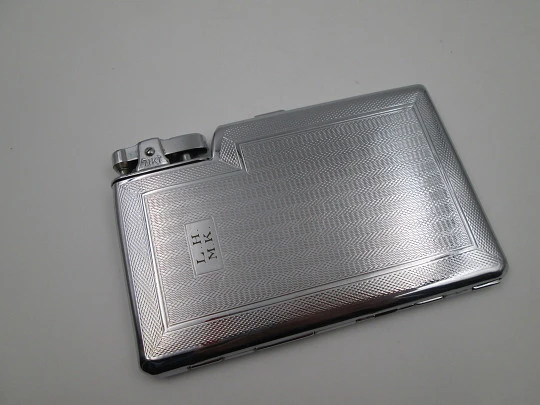 Tiki cigarette case with petrol lighter. Silver plated metal. Waves motifs. England. 1960's