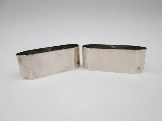 Two napkin rings. Sterling silver. Basket with fruits. Floral motifs. Europe. 1950's