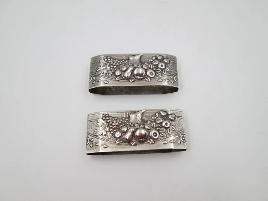 Two napkin rings. Sterling silver. Basket with fruits. Floral motifs. Europe. 1950's