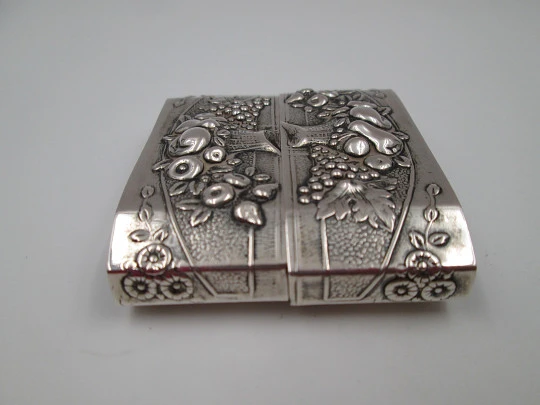 Two napkin rings. Sterling silver. Basket with fruits. Floral motifs. Europe. 1950's