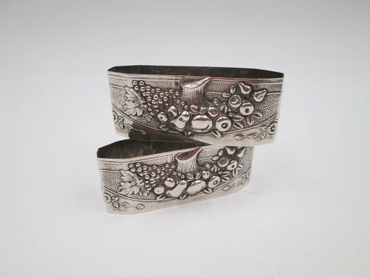 Two napkin rings. Sterling silver. Basket with fruits. Floral motifs. Europe. 1950's