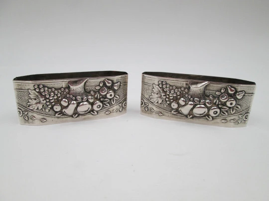 Two napkin rings. Sterling silver. Basket with fruits. Floral motifs. Europe. 1950's