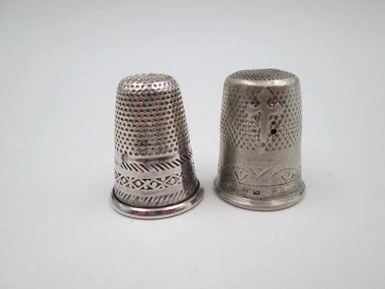 Two sewing thimbles. Sterling silver. Geometric motifs and cross. Spain. 1970's