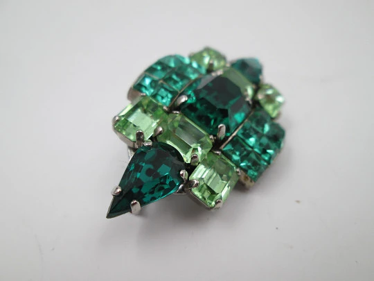 Women's brooch. Silver plated metal. Green faceted stones. United States. 1960's