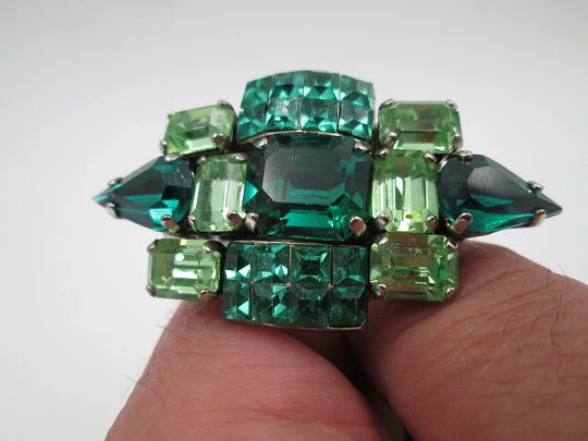 Women's brooch. Silver plated metal. Green faceted stones. United States. 1960's