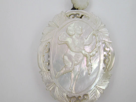 Women's photo frame pendant. Nacre and gold plated. Chiselled cherub. Europe. 1940's